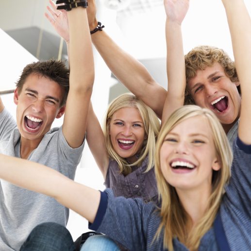 Young friends with arms raised in success